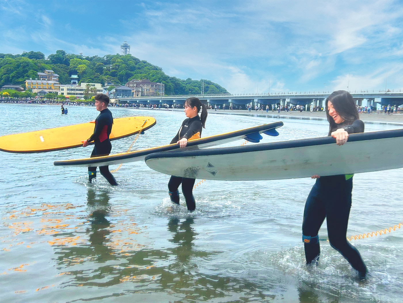 体験サーフィンで海に向かう三人のイメージ